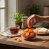Asia Trade Caucasian sour plums in a glass bowl on a wooden table with a hand picking one, 500g pack.
