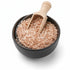 Asia Trade Devzira rice in a black bowl with a wooden scoop, showcasing the unique reddish-brown grain texture.