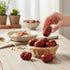 Asia Trade natural dried Chinese jujube plums in a small wicker basket on a wooden table