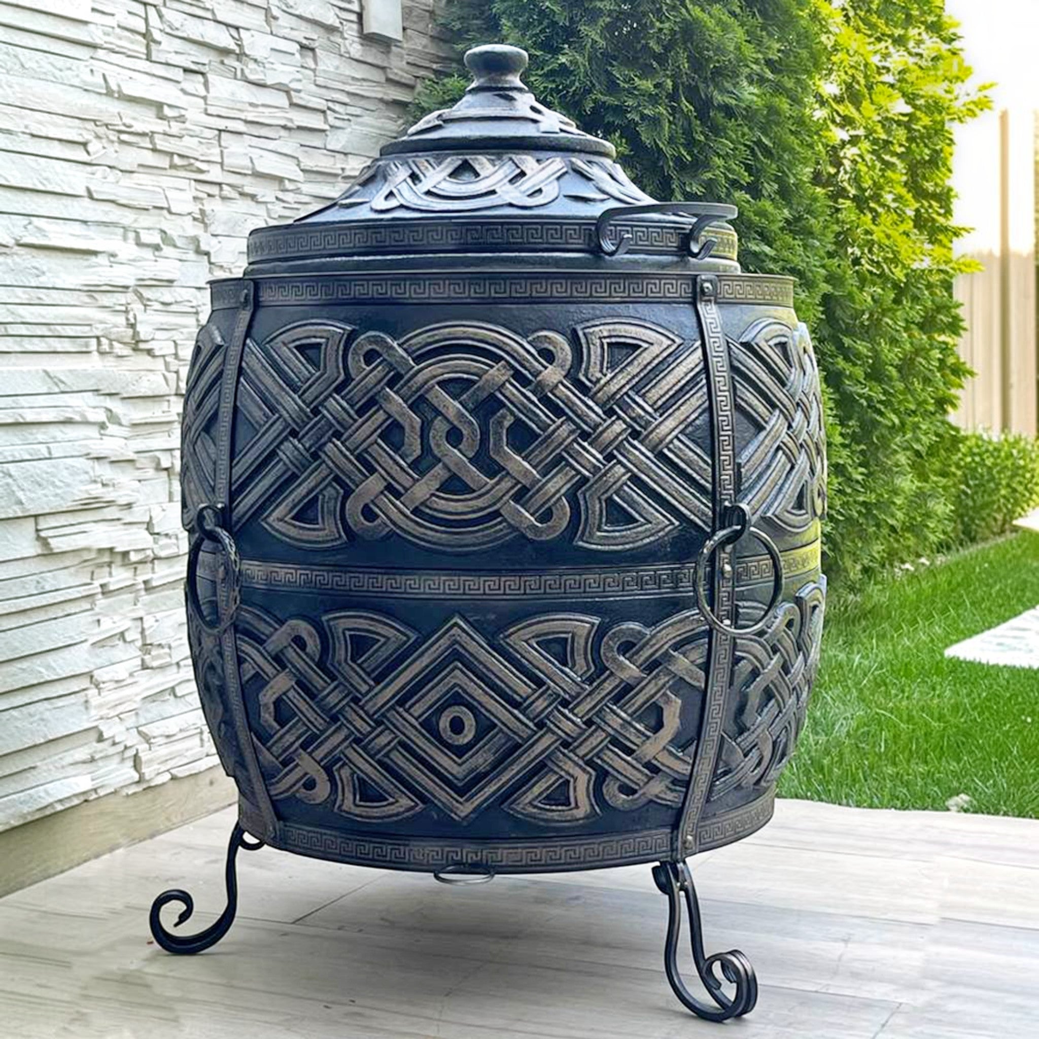 Asia Trade Exclusive insulated tandoor oven with ornate black and bronze Celtic-style metalwork and lid.
