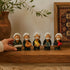 Asia Trade handcrafted Uzbek ceramic figurines of elderly men in traditional attire on a wooden shelf