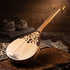 Asia Trade traditional Kazakh dombra string instrument with intricate wooden carvings on a rustic wooden table