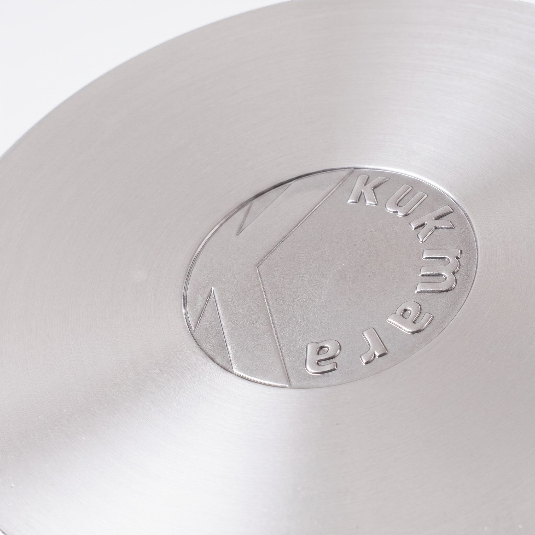 Asia Trade Kukmara cast aluminum pot base with embossed logo, showing durable metal construction for even heating.