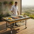 Asia Trade mosaic tile outdoor grill table with metal frame and wooden handles being used by a man on a patio