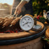 Asia Trade tandoor oven thermometer with a stainless steel dial measuring up to 500 degrees Celsius on a clay oven