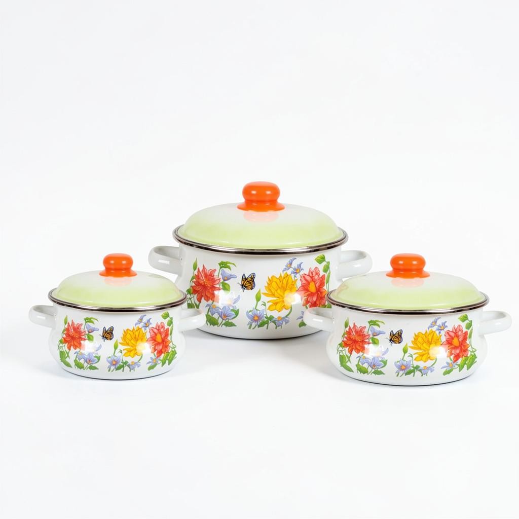 Asia Trade set of three white enamel pots with floral butterfly patterns and orange lids in varying sizes