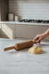 Asia Trade traditional wooden pasta rolling pin with grooved design for dough, held by hand on a marble kitchen counter
