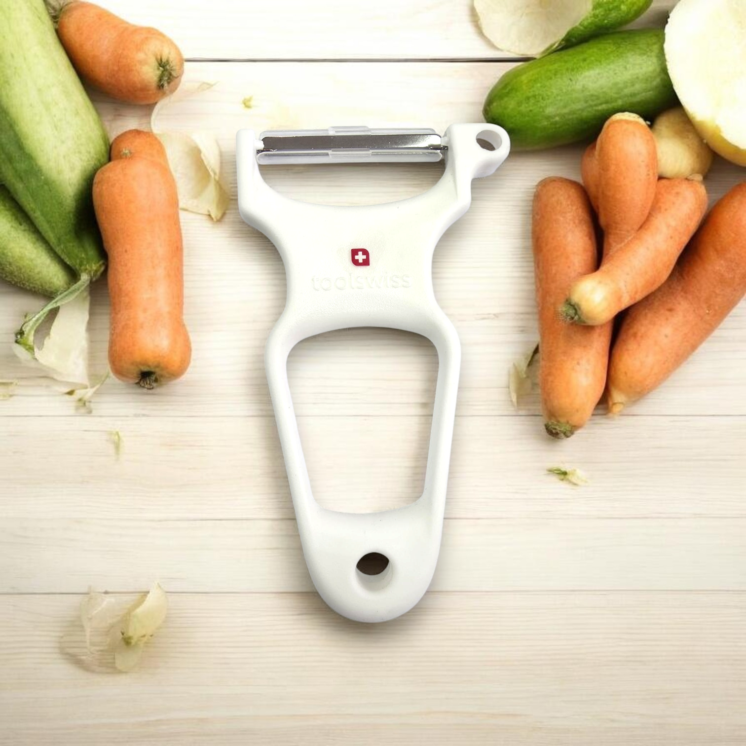 קולפן toolswiss Clasinox על משטח עץ עם גזר ומלפפונים